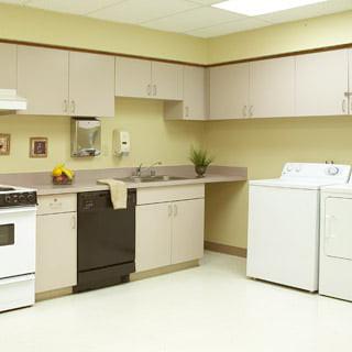 A kitchen and laundry area featuring a stove, dishwasher, and washer-dryer set.