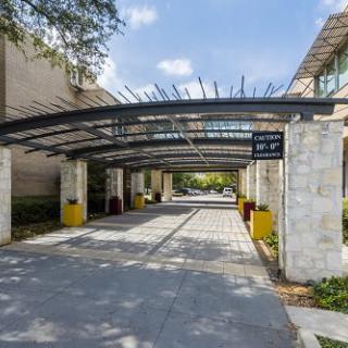 A modern building entrance with a covered walkway on a sunny day.
