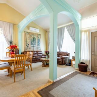 A cozy living room and dining area with an archway and bright decor.