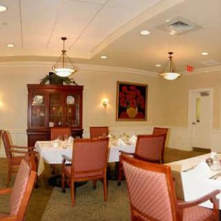 A cozy dining room with neatly set tables and warm lighting.
