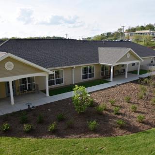 A modern single-story building surrounded by a landscaped garden.