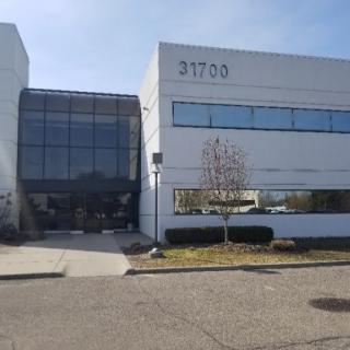 A modern commercial office building with large windows and a clean exterior design.