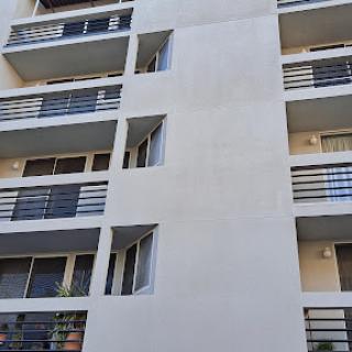 A modern apartment building featuring multiple balconies and a clean exterior.