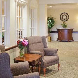A cozy lobby with comfortable chairs and a small table adorned with flowers.