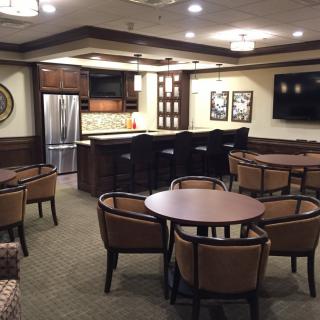 A modern kitchen and seating area featuring a bar counter with chairs and tables.