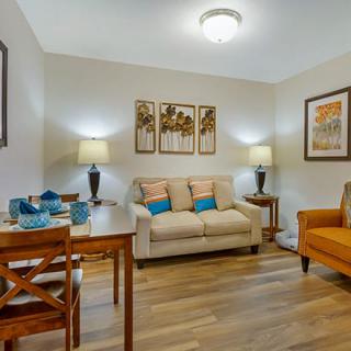 A cozy and stylish living room featuring a comfortable sofa, dining set, and tasteful decor.