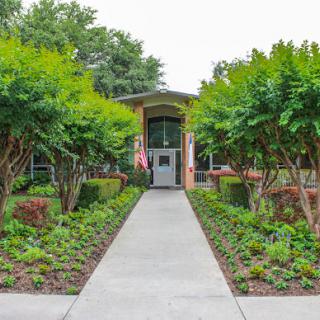 A welcoming entrance with a neatly manicured pathway and lush greenery.