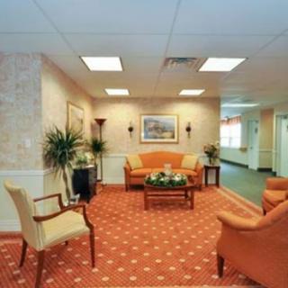 A cozy lobby area with orange seating and traditional decor.