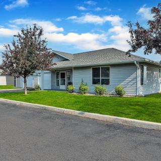 A suburban house with a well-maintained lawn and clear blue sky.