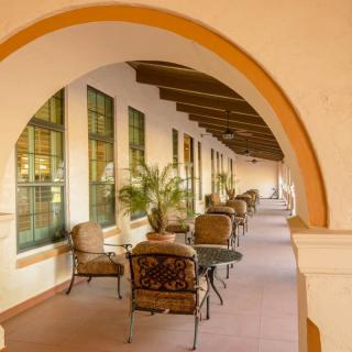 Outdoor patio with archways and seating area in a Mediterranean architectural style.