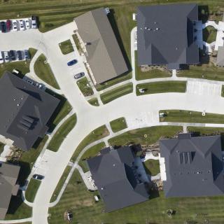 Aerial view of a suburban neighborhood with houses and winding roads.