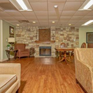 Cozy living room with a stone fireplace and wooden flooring.