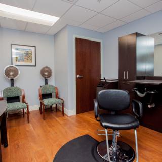 A well-organized hair salon interior featuring styling chairs, mirrors, and hair dryers.