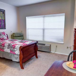 A cozy bedroom with a single bed and bright window light.