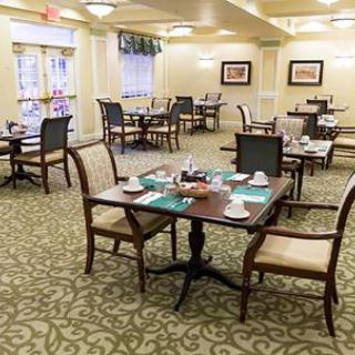 A neatly arranged dining room with tables and chairs set for a meal.