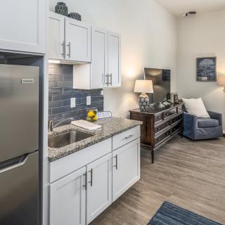 A modern apartment interior featuring a compact kitchen and cozy living area.