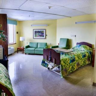 A well-equipped hospital room with a bed, sofa, and medical equipment.