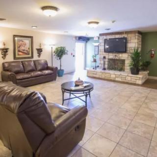 A cozy living room with sofas, a coffee table, and a fireplace under a mounted TV.