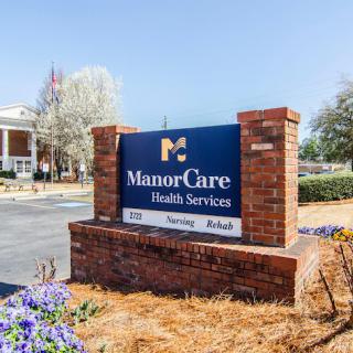 Sign for ManorCare Health Services in front of a healthcare facility.