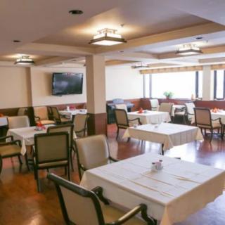 An empty restaurant dining area with neatly arranged tables and chairs.