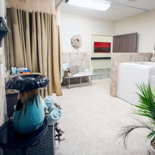 A modern bathroom setup featuring a washing machine, decorative elements, and a touch of greenery.