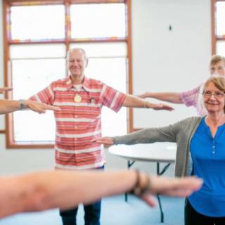 A group of seniors participating in a fitness class at a community center.