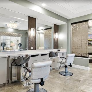 A modern hair salon interior with stylish chairs and mirrors.