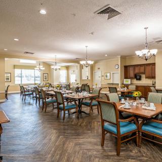 A spacious and well-lit dining area with neatly arranged tables and chairs.