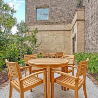 A cozy outdoor seating area with a wooden table and chairs set against a brick wall.