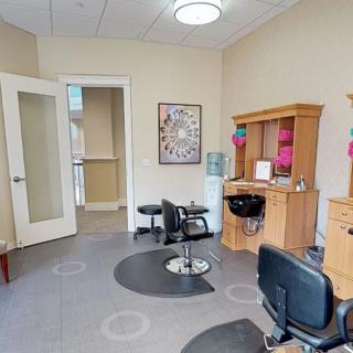 A well-equipped salon interior with haircut stations and mirrors.