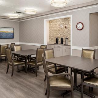 A modern dining area with neatly arranged tables and chairs, featuring neutral colors and elegant interior design.