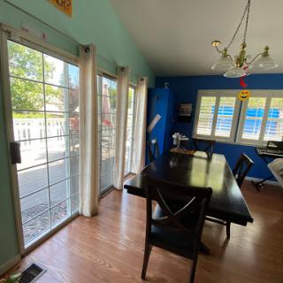 A bright and inviting dining area with blue walls and a large table, perfect for gatherings.