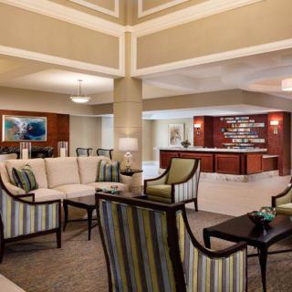 A spacious hotel lobby with comfortable seating and a reception desk.