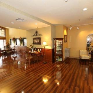A spacious living room with polished wood flooring, elegant furniture, and decorative elements.