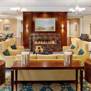 A cozy living room with elegant furniture, a central fireplace, and tasteful artwork.