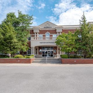 A well-maintained building featuring elegant architecture and surrounding greenery.