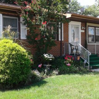 A charming house with a well-maintained garden and lush green lawn.