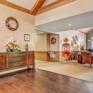 A cozy living room with wooden floors, featuring comfortable seating and elegant decor.