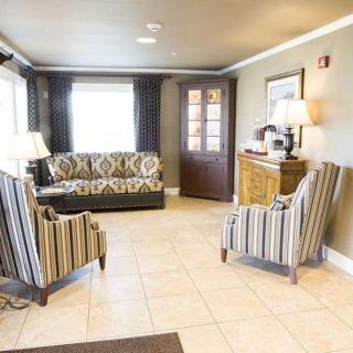 A cozy lobby area featuring patterned sofas and chairs with a coffee station.