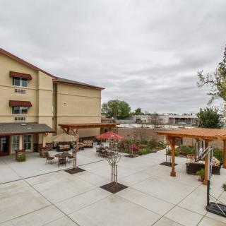 A courtyard with outdoor seating in front of a multi-story building on an overcast day.
