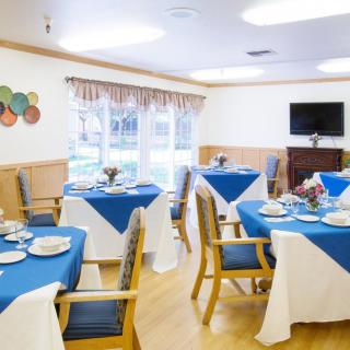 A neatly arranged dining area with blue and white tablecloths, set for a meal.