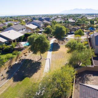 A scenic aerial view of a suburban neighborhood with houses, trees, and a pathway.