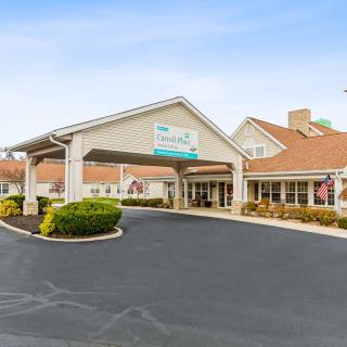 The entrance to a hotel with a covered driveway and landscaped surroundings.
