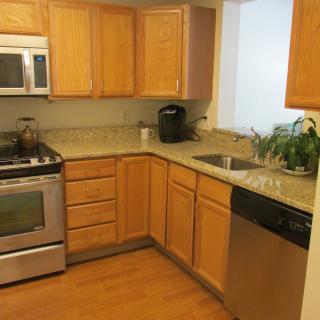 Modern kitchen with wooden cabinets and stainless steel appliances.