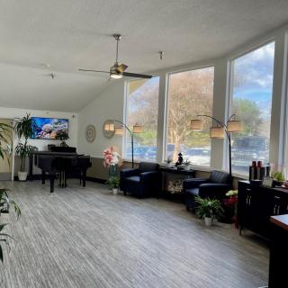 A bright and spacious lobby with a piano and seating area by large windows.