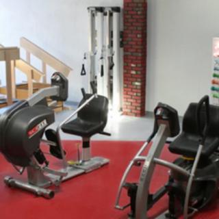 A gym with various exercise machines and equipment.