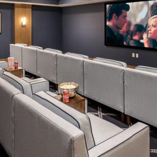 A luxurious home theater with comfortable seating and a large screen.