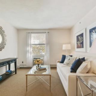 A modern and elegantly decorated living room featuring a comfortable sofa, stylish mirror, and contemporary artwork.