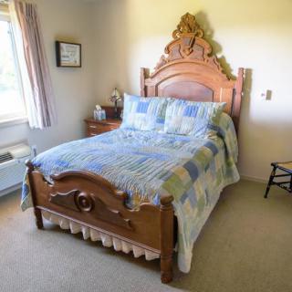 A cozy bedroom featuring an antique wooden bed with a decorative headboard and a patchwork quilt.