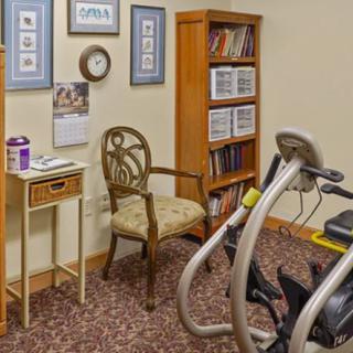 A cozy corner with exercise equipment and a bookshelf, blending fitness and leisure in a home setting.